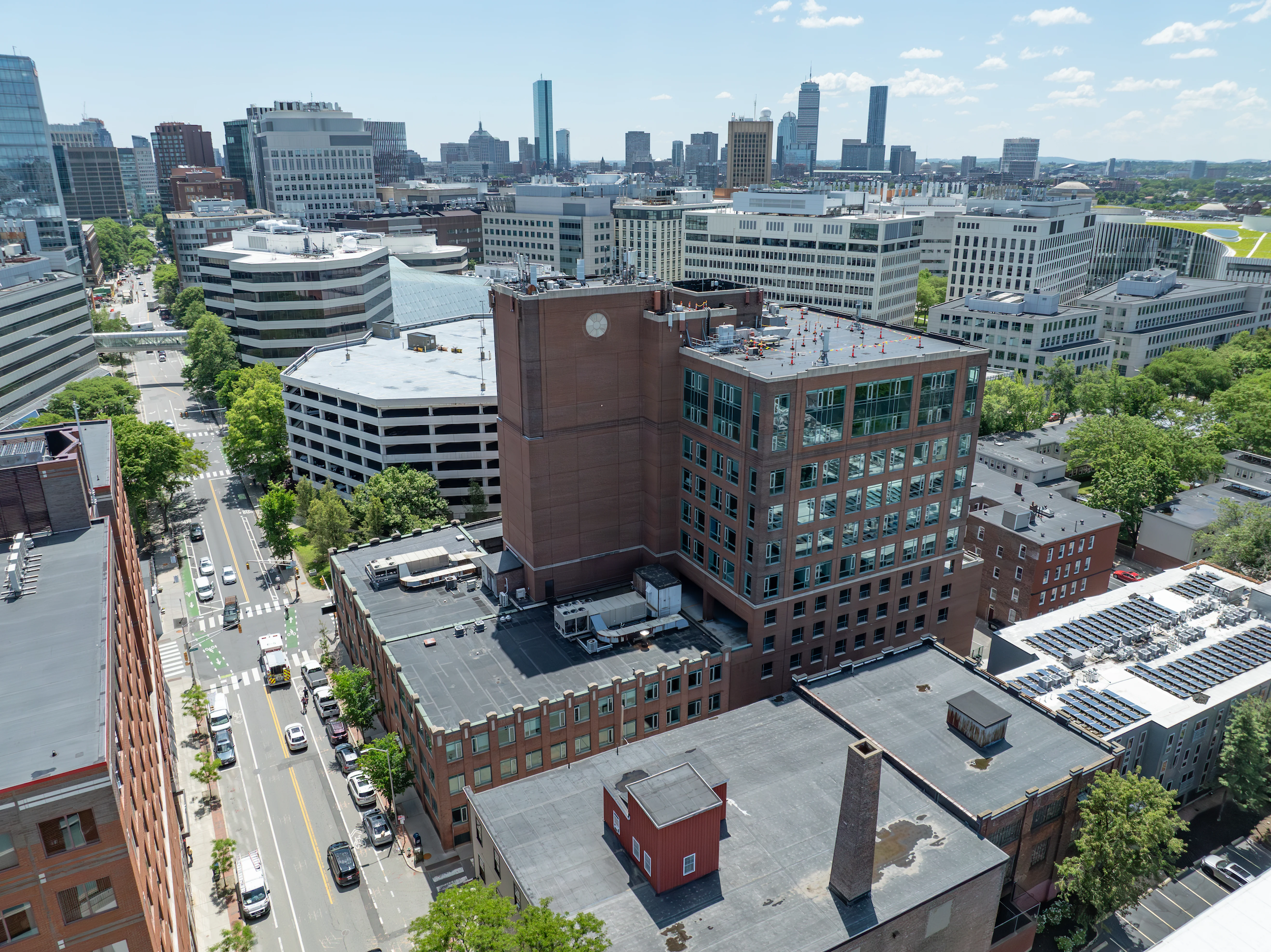 An aerial view of the building centered around other buildings on a sunny day